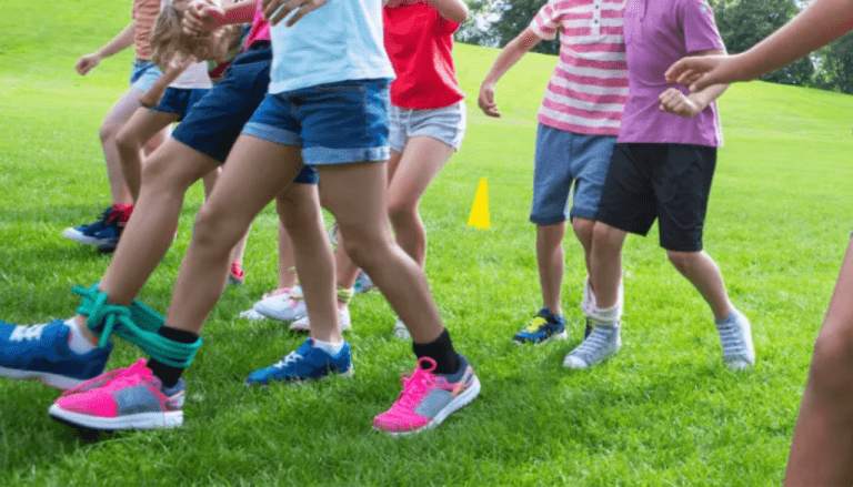 Cada jugador se coloca al lado de su pareja y se les ata una pierna a la del otro.