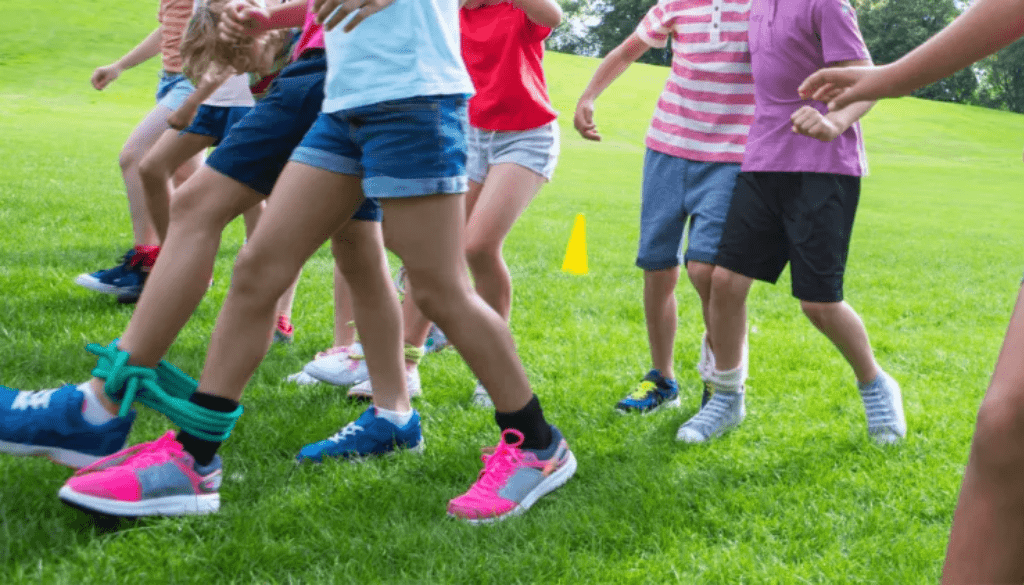 Cada jugador se coloca al lado de su pareja y se les ata una pierna a la del otro.
